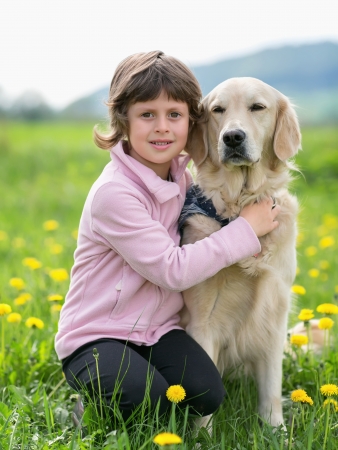 A little blond girl with her pet dog outdooors in park の写真素材