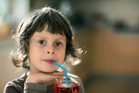 Nice girl drinking through a straw drinkの写真素材
