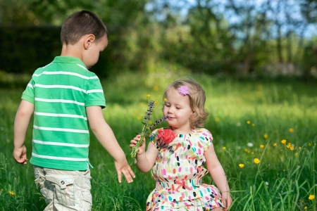The little boy gives a flower their little sisterの写真素材