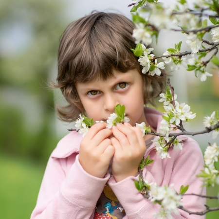 Cute baby smells to blossom treeの写真素材