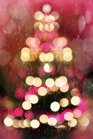 Abstract christmas tree formed by blurred lights during the falling snowの写真素材