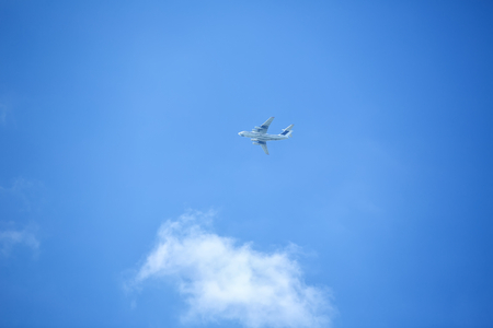 Flying airplane on the blue sky leaving white lines behindの写真素材