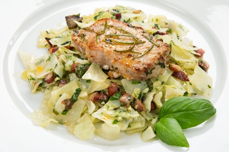 Pork chop with basil pesto, cabbage and baconの写真素材