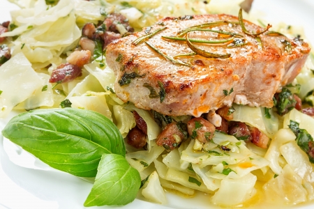 Pork chop with basil pesto, cabbage and baconの写真素材