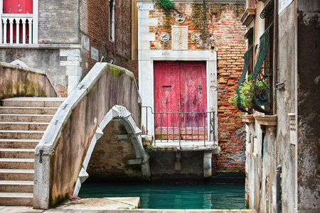 Narrow canal among old colorful brick houses in Venice, Italy.の写真素材