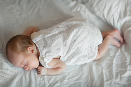 Newborn baby girl asleep on a blanketの写真素材