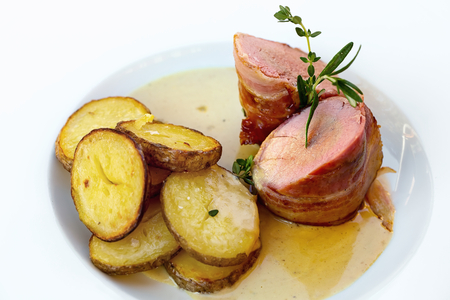 Roasted pork tenderloin with bacon roasted potatoesの写真素材