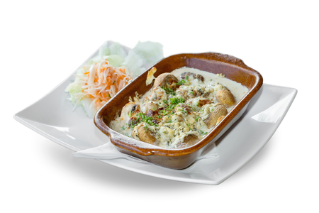 baked mushrooms with cream sauce on a white backgroundの写真素材