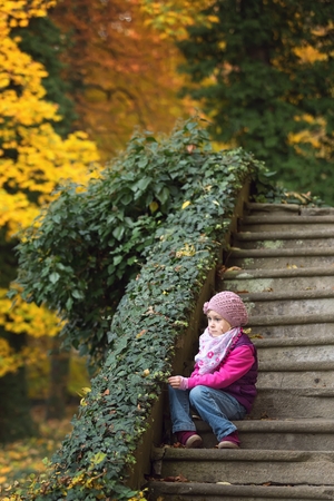 Children sitting on old stone stairs in the parkの写真素材