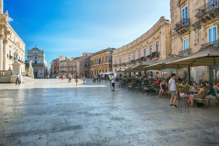SYRACUSE, ITALY - JUL 26, 2016: tourists and locals visit the main square and a local restaurant at the Piazza del Duomo in Ortigia, Syracuse, Italy. Ortigia is a small island Which is the historical center of Syracuse, Sicily.のeditorial素材