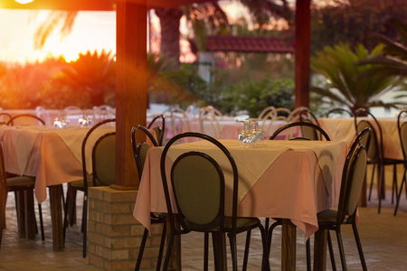 Empty outdoor restaurant table at sunsetの写真素材