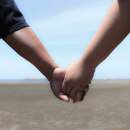 Holding hands on the beach.