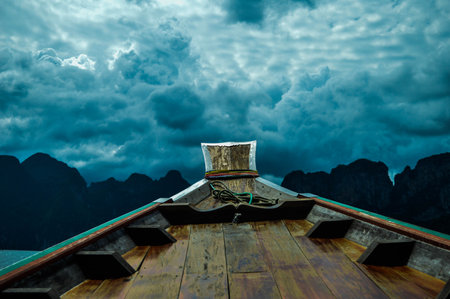 Holiday travel by local small boat at southern of Thailand, on the cloudy day with greenery mountains and trees background.の写真素材