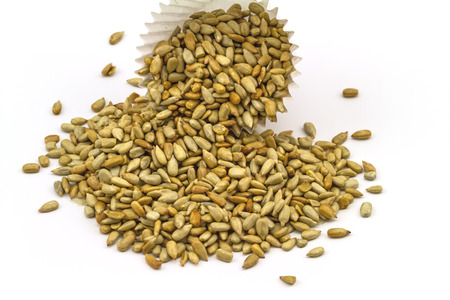 fresh sunflower seeds in paper cup isolated on a white backgroundの写真素材