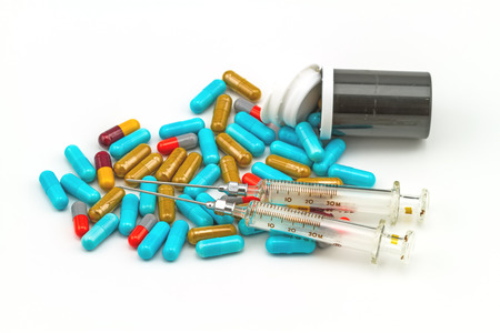colorful pills  syringe and black bottle tablets on white backgroundの写真素材