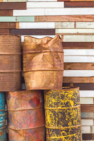 old fuel tanks that lay altogether and grunge wooden backgroundの写真素材