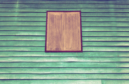 Old brown window with green wall is suitable for use as a backgroundの写真素材