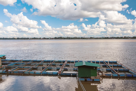 The bamboo coop for feeding fish in Mekong river on blue sky and big cloudの写真素材