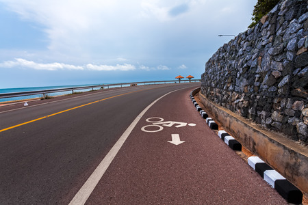 Beautiful bicycle road sign in the curve road near the ocean at Nern Nang Phaya viewpoint. Chanthaburi Province,Thailandの写真素材