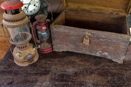 Vintage oil lamp ,old wooden box  and alarm clock on old wooden touch-up in still life conceptの写真素材