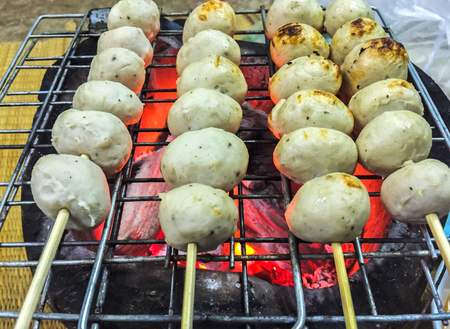 Thai street food pork meatball toast with skewer stick on the grille.の写真素材