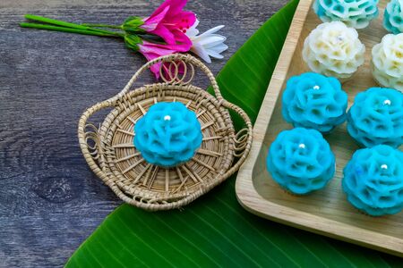 Traditional Thai dessert flower shape stuff with crush soybean and taro (Thai name kanom Chor phaka) in bamboo basket and bana leaf.の写真素材