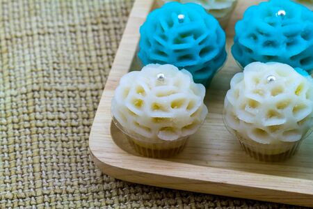 Close up traditional Thai dessert flower shape stuff with crush soybean and taro (Thai name kanom Chor phaka) in wooden basket on fabric sisal.の写真素材