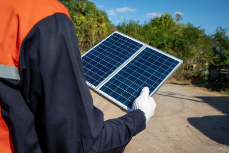 Male engineer holding small photovoltaic solar panelsto install. Clean and green alternative energy concept.の写真素材