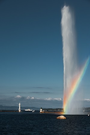 A beautiful rainbow colors the mist on the symbol of Geneva, a 140m water fountain on Lake Geneva called the Jet D'eau.の写真素材