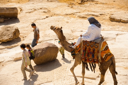 CAIRO - OCTOBER 26: A persistent camel guide chases and nags an uninterested family of tourists October 26, 2010 at Cairo, Egyptのeditorial素材