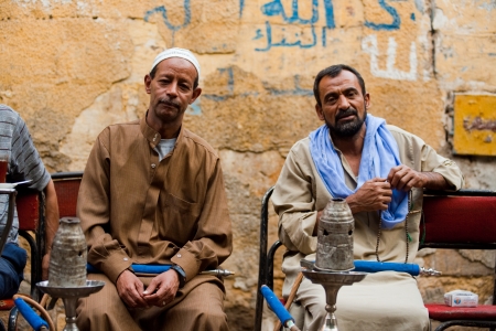 CAIRO - OCTOBER 11: A pair of Egyptian men enjoy smoking shisha at a traditional streetside ahwa (cafe) in Islamic Cairo October 11, 2010 at Cairo, Egyptのeditorial素材