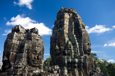 Two towers of happy faces against a beautiful blue sky at the Bayon temple in the Angkor Wat temple complex in Siem Reap, Cambodiaの写真素材