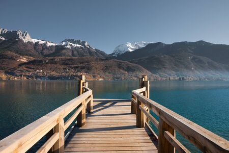 Snow capped  French Alps mountains seen from a pier on Annecy Lakeの写真素材