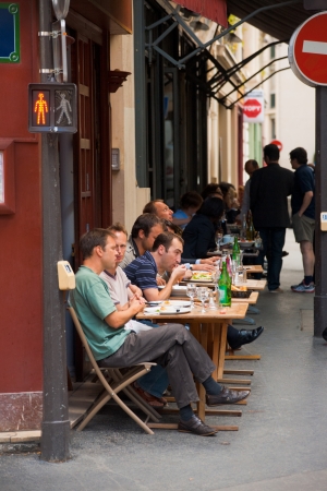 Paris, France - July 6, 2011: Lunch at a Parisian street cafe on a narrow sidewalk. Sidewalk cafes are a daily part of a typical life in Paris July 6, 2011 at Paris, Franceのeditorial素材