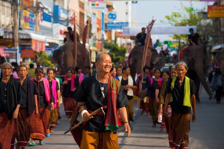 SURIN, ISAN, THAILAND - NOVEMBER 19, 2010: A Surin village elder leads a group of traditional dress villagers in a parade at the annual Surin Elephant Roundup on November 19, 2010 in Surin, Thailandのeditorial素材