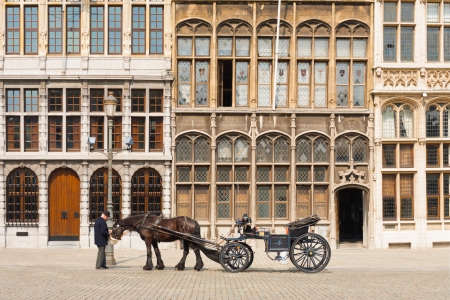 ANTWERP, BELGIUM - APRIL 14, 2010: A traditional horse-drawn buggy at the guildhouses at Grote Markt awaits toursist to tour the famous sights in the old city on April 14, 2010 in Antwerp, Belgiumのeditorial素材