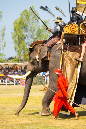 SURIN, THAILAND - NOVEMBER 20, 2010: Soldiers and king ride an elephant during the Siamese Burmese war reenactment at the Surin Elephant Roundup on November 20, 2010 in Surin, Thailandのeditorial素材