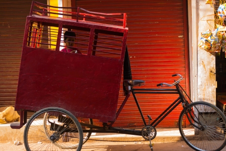 DELHI, INDIA - OCTOBER 27, 2009: A young student rides a shared cycle rickshaw to school on October 27, 2009 in Delhi, India. Shared school buses are not provided by the state in Indiaのeditorial素材