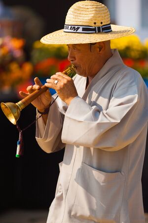 SEOUL, KOREA - SEPTEMBER 18, 2009: An unidentified mature Korean man in traditional clothes plays an old reed instrument, taepyeongso at a local outdoor festival on September 18, 2009 in Seoul, Koreaのeditorial素材