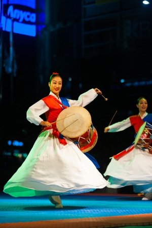 SEOUL, KOREA - SEPTEMBER 17, 2009: An unidentified Korean women in hanbok spins and plays traditional janggu drums at a free open-air summer show near city hall on September 17, 2009 in Seoul, Koreaのeditorial素材
