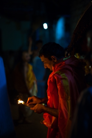 GOKARNA, INDIA - MARCH 26, 2009: Unidentified Indian brahmin blesses a residence by burning incense at night during a monthly full moon hindu ceremony on March 26, 2009 in Gokarna, Indiaのeditorial素材