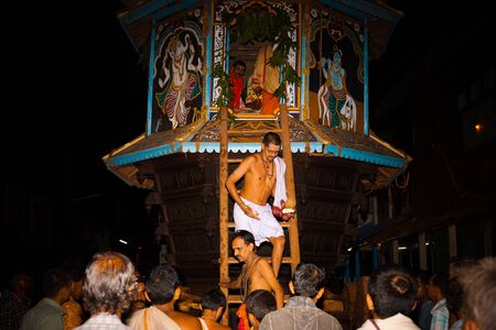 GOKARNA, INDIA - MARCH 26, 2009: Unidentified brahmin priest exits the small ratha chariot during a...