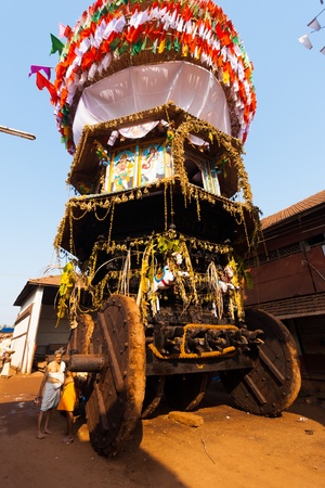 GOKARNA, INDIA - MARCH 3, 2009: Unidentified brahmin priests chat next to the large wheels of the big ratha chariot, a vehicle used in Gokarna for hindu festivals, on March 3, 2009 in Gokarna, Indiaのeditorial素材