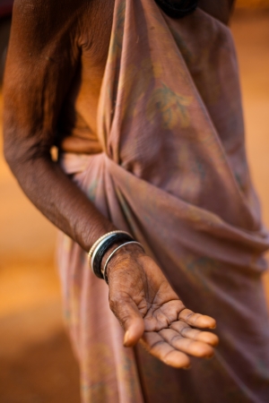 GOKARNA, INDIA - MARCH 9, 2009: A poor old Indian senior woman extends her hand and palm to ask for money and change on March 9, 2009 in Gokarna, Indiaのeditorial素材
