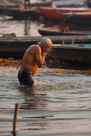 VARANASI, INDIA - JANUARY 29, 2008: An unidentified hindu Indian man takes a morning bath, an important cultural tradition, in the holy Ganges river on January 29, 2008 in Varanasi, Indiaのeditorial素材