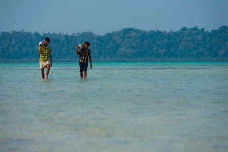Havelock, India - April 21, 2008: Unidentified workers carry diving oxygen tanks on April 21, 2008 in Havelock, India. Tourism has helped employ the local population of the Andaman Nicobar Islandsのeditorial素材