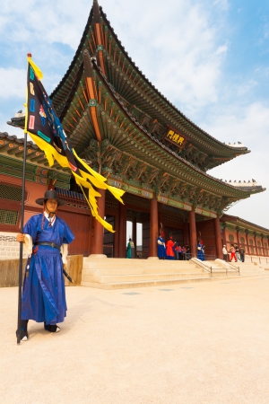 SEOUL, KOREA - SEPTEMBER 17, 2009: A flag guard in ancient blue Korean costume stands at the entry gate of Gyeongbokgung Palace, the old royal residence, in Seoul, South Korea on September 17, 2009のeditorial素材