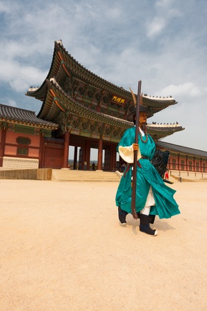 SEOUL, KOREA - SEPTEMBER 17, 2009: A guard in traditional green Korean outfit walks out of Gyeongbokgung Palace, the old royal residence, in Seoul, South Korea on September 17, 2009のeditorial素材