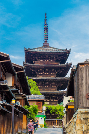 KYOTO, JAPAN - JUNE 15, 2015: Tourists walking in ront of Yasaka No To pagoda and traditional wooden buildings on a touristy street in late afternoon on a sunny clear blue sky dayのeditorial素材