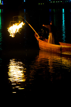 Inuyama, Japan - July 5, 2015: A bird on a traditional wooden boat prepares to perform ukai cormorant fishing by night flames on Kiso River in Gifu prefectureのeditorial素材